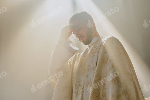 Preview: Priest in White Robe Crossing Himself