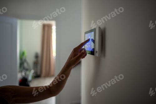 Preview: Closeup hand using smart home panel, touching screen with connected appliances device on wall.