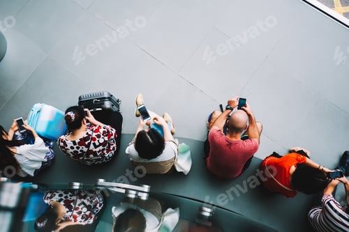 Preview: Multiracial group of people sitting at airport