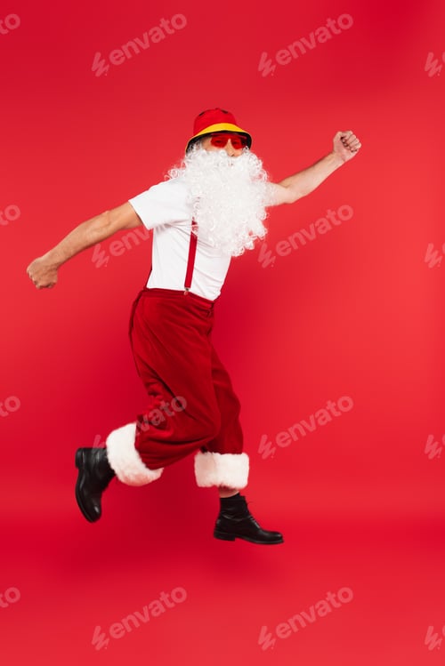 Preview: Santa claus in sunglasses levitating isolated on red