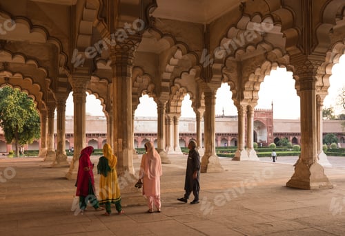 Preview: Visitors exploring the serene arches of a historical palace.