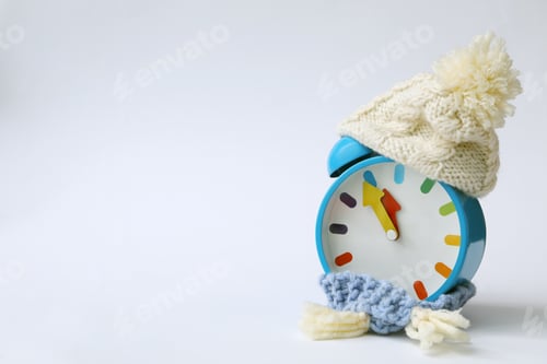 Preview: Alarm clock in hat on white background. New Year countdown