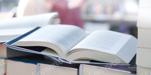 Preview: stack of books on the table. open book