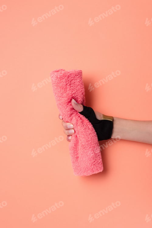 Preview: Cropped view of female hand with towel on beige background
