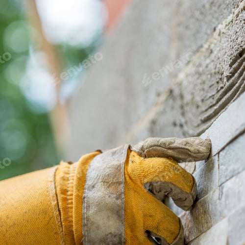 Preview: Pressing an ornamental tile into a glue on a wall