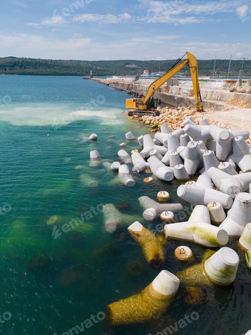 Preview: An excavator diligently constructs a dock or breakwater in the sea, its mighty arm reaching out from