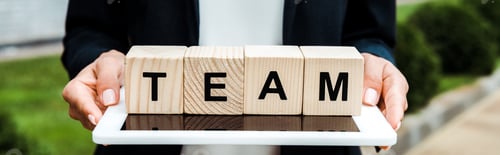 Preview: panoramic shot of woman holding digital tablet and wooden cubes with team letters