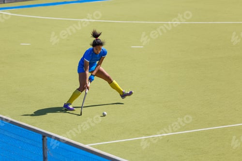 Preview: Young female field hockey player passing the ball through the pitch