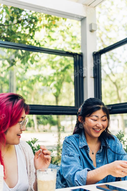Preview: Female friends laughing and having fun, sitting in a cafe having breakfast