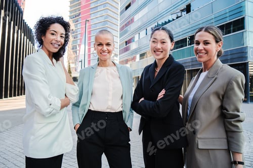 Preview: Group of good looking business women standing at workplace and posing for the portrait with