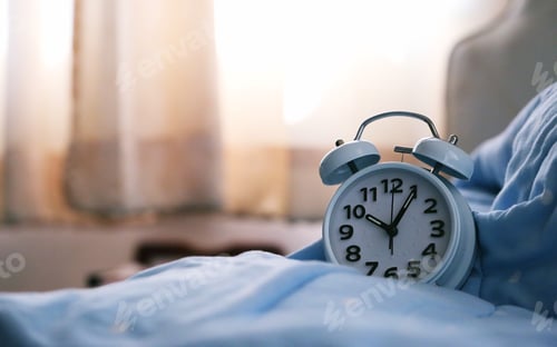 Preview: Alarm clock on soft blue blanket in bedroom blur background