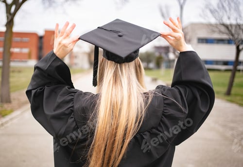 Preview: Rear view of young female graduate adjusting graduation cap, celebrating academic achievement