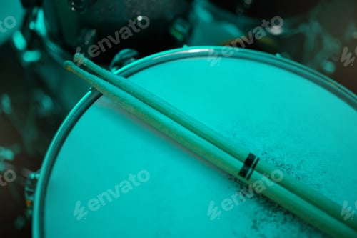 Preview: Top view of sticks on drums instrument in music studio, production or live band in neon green light