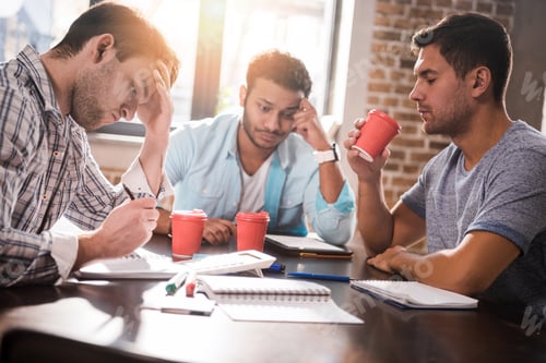 Preview: Group of concentrated young professionals working on business project together