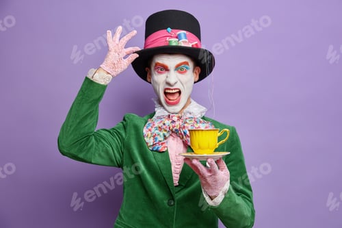 Preview: Angry man hatter has tea ceremony looks crazy wears hat lace gloves and green jacket exclaims with n