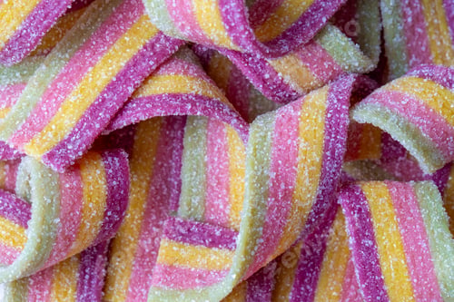 Preview: Colorful jelly candies strips in sugar sprinkles. Sour flavored rainbow candy background