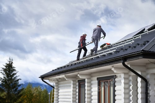 Preview: Technicians carrying photovoltaic solar module while installing solar panel system on roof of house