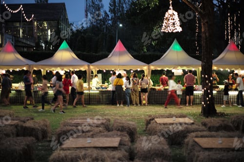 Preview: Blurred motion people walk in the food festival at night with decorative bokeh light in background