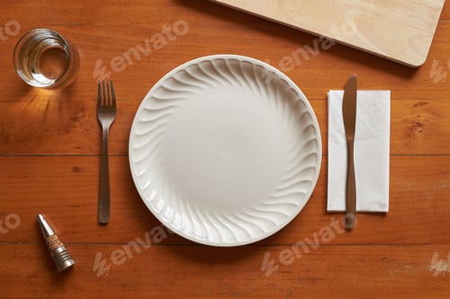 Preview: Porcelain plate and cutlery against a wood background