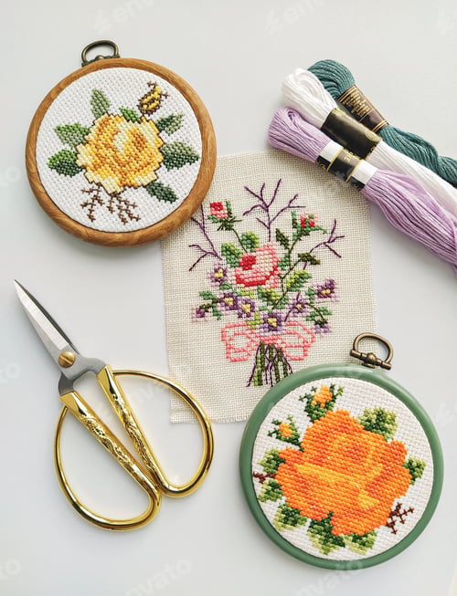 Preview: Vintage wooden embroidery hoops, scissors, needle, thread and fabric with floral cross-stitch embroi