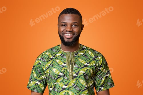 Preview: African man in green authentic clothes posing over yellow background