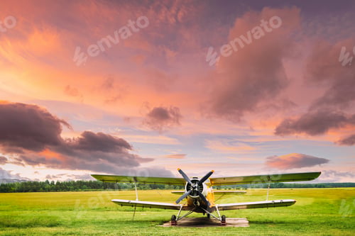 Preview: Old Retro Plane Aircraft Aeroplane, Airplane Biplane Parked In Grass Airfield. Altered Sunset