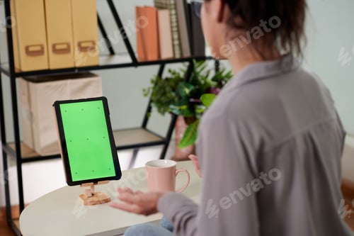 Preview: Close-up of young businesswoman or freelancer sitting in front of tablet