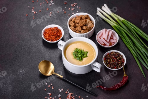 Preview: Cream soup with potatoes, leek and peas on a dark concrete table