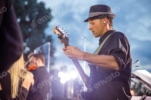 Preview: Man Plays Guitar with Orchestra in Background