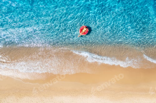 Preview: Aerial view of a young woman swimming with red swim ring