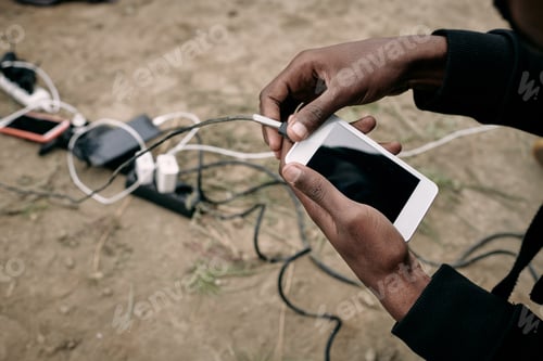 Preview: Hand of male migrant hoding smartphone while going to call