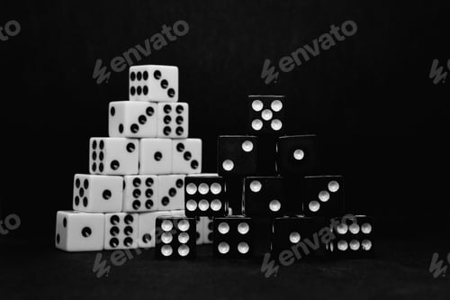 Preview: Close up of black and white dice stacked in the shape of a pyramid isolated on a black background