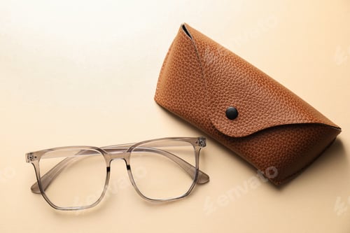 Preview: Case with stylish glasses on beige background, flat lay