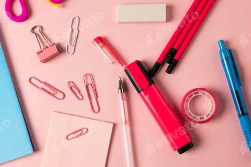 Preview: Composition of pink and red school equipment with clips and tape on pale pink surface