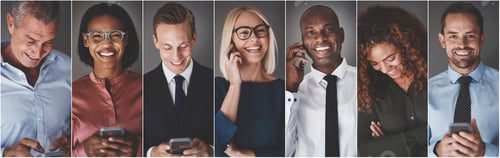 Preview: Diverse group of smiling business professionals using cellphones
