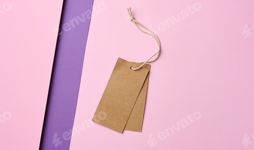 Preview: Empty brown tags on a rope, pink background. Price template, top view