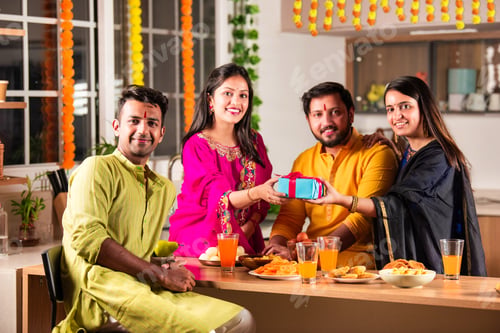 Preview: Happy Indian family and friends celebrating Diwali at home, sharing food and laughter