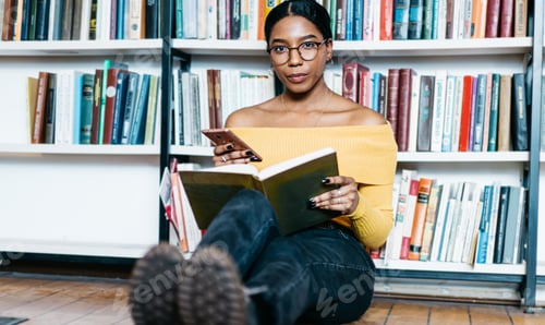 Preview: Woman with phone reading book in library