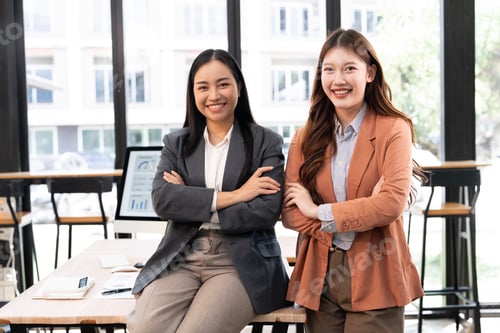 Preview: Two confident and successful young Asian businesswomen posing with arms crossed,