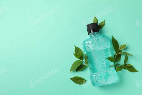 Preview: Mouthwash and leaves on mint background, space for text