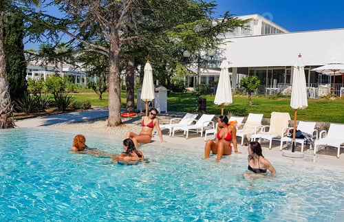 Preview: Attractive girls sitting by the pool.