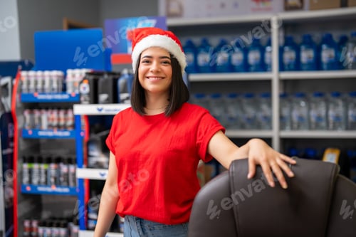 Preview: Happy saleswoman celebrating christmas, working in a retail automobile parts shop