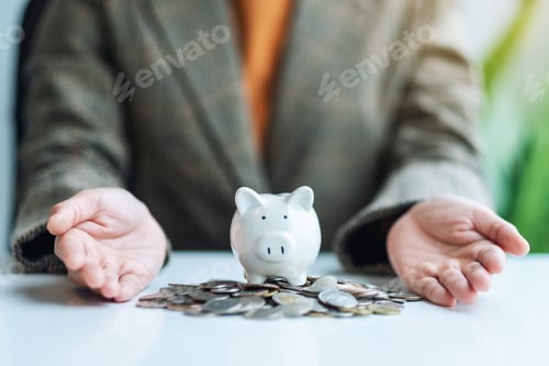 Preview: Closeup image of a woman's hands showing piggy bank and coins on the table for saving money concept