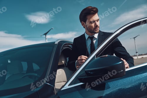 Preview: Business travel. Handsome young man in business wear entering his car while standing outdoors
