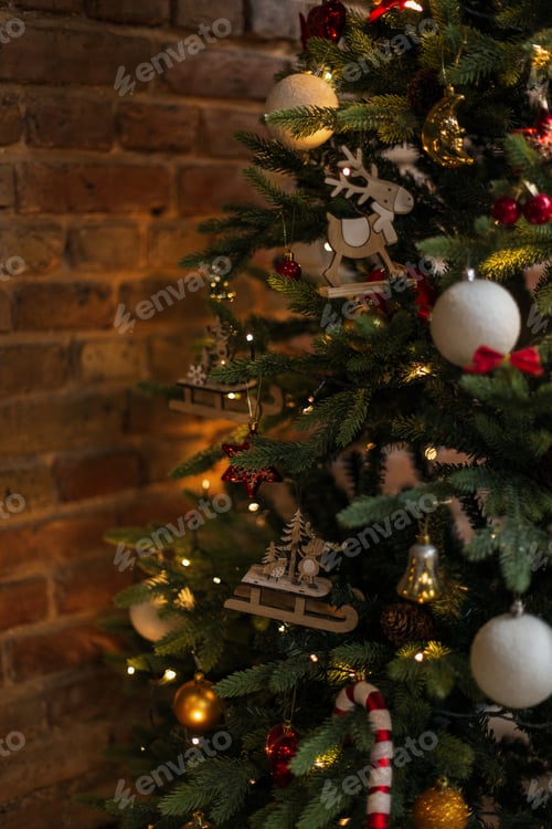 Preview: Beautiful Christmas tree with vintage toys and lights near a brick wall at Christmas Eve