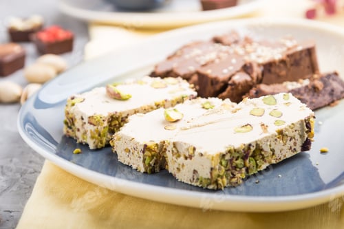 Preview: traditional arabic sweets sesame halva with chocolate and pistachio and a cup of coffee on a gray