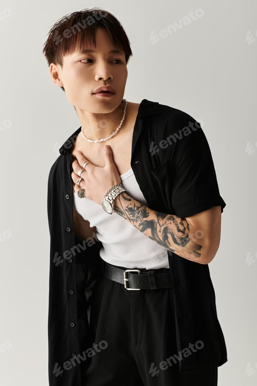 Preview: Stylish young Asian man poses confidently in trendy attire against a minimalist backdrop