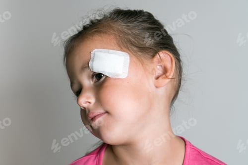 Preview: Cute brave lovely, adorable dark haired little child, girl with patch bandage on face, show to