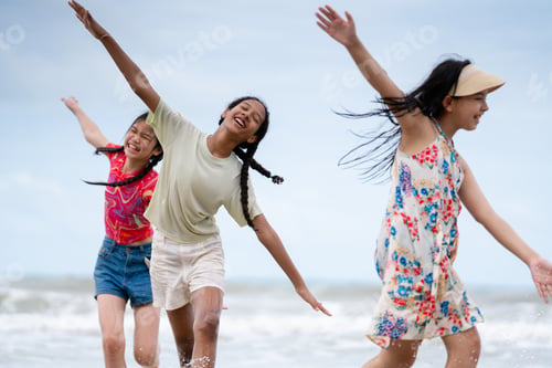 Preview: Happy children laughing and enjoying at beach. Kids playing with friends at the sea.