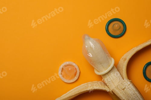 Preview: Condom on a banana on a yellow background,place for text